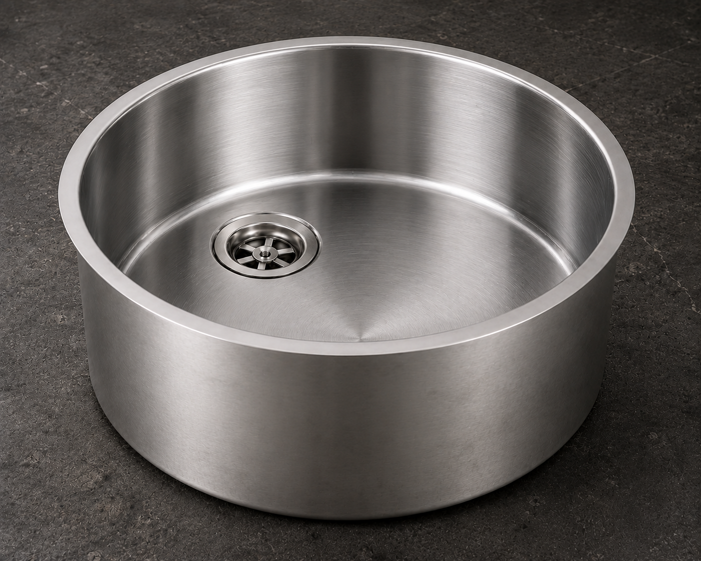 Rundes Spülbecken aus Edelstahl mit modernem Design und zentralem Abfluss, ideal für Küchen und Nutzräume.